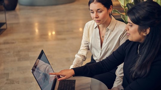 Two women working on laptop