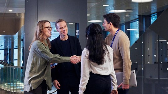 People meet and greet smiling shaking hands